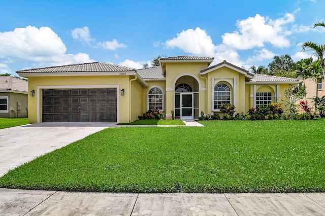 mediterranean / spanish house featuring a front yard and a garage