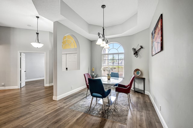 dining room featuring a textured ceiling, dark hardwood / wood-style floors, and an inviting chandelier