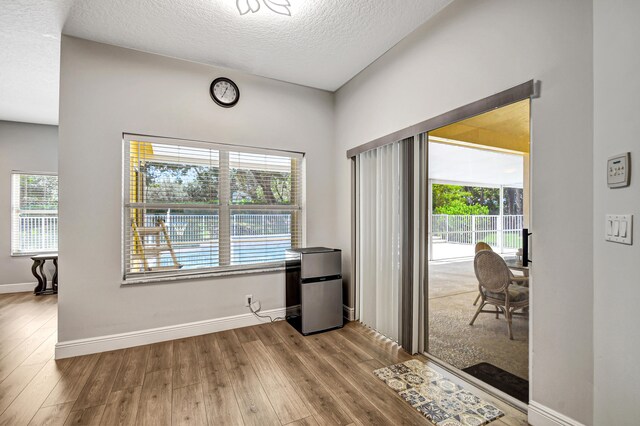 interior space featuring a textured ceiling and light hardwood / wood-style flooring