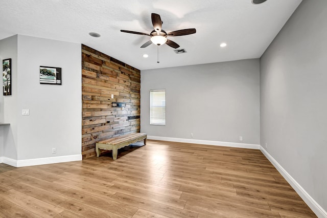 unfurnished room with a textured ceiling, light hardwood / wood-style flooring, and ceiling fan