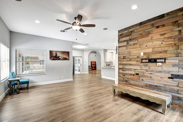 sitting room featuring a textured ceiling, light hardwood / wood-style floors, and ceiling fan