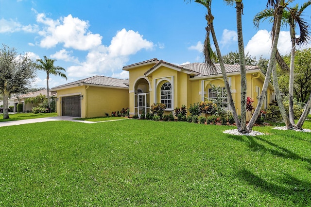 mediterranean / spanish-style home featuring a garage and a front yard