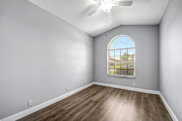 empty room featuring a textured ceiling, dark hardwood / wood-style flooring, ceiling fan, and lofted ceiling