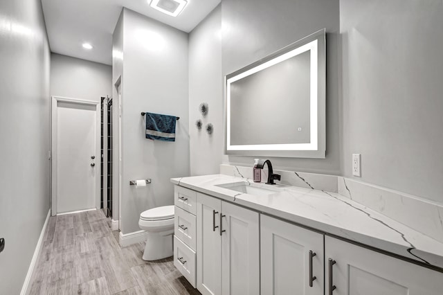 bathroom featuring vanity, hardwood / wood-style flooring, and toilet