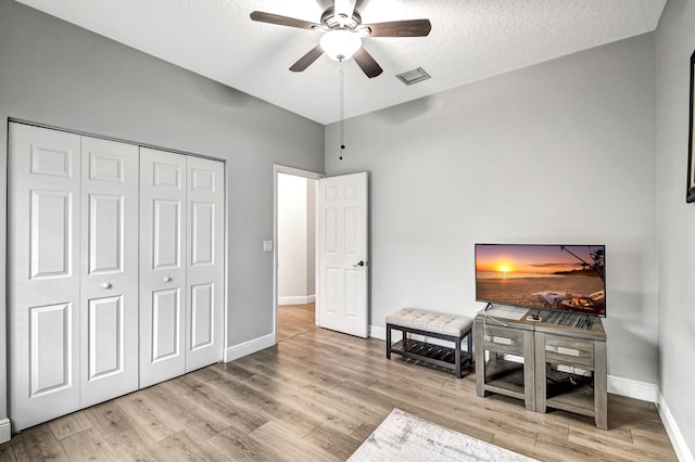 sitting room featuring ceiling fan, light hardwood / wood-style floors, and a textured ceiling