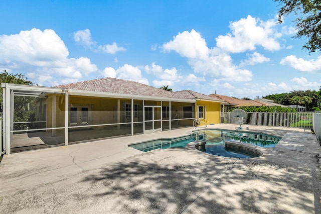 view of swimming pool featuring a hot tub, a patio area, and a sunroom