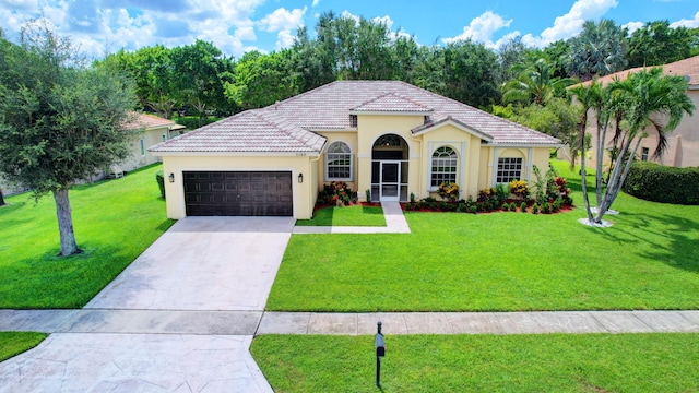 mediterranean / spanish house with a front yard and a garage