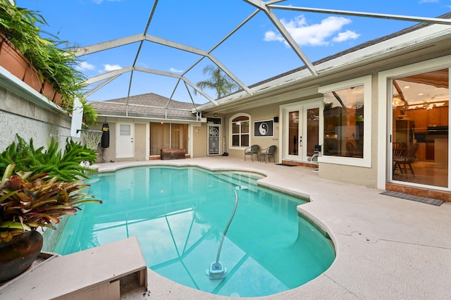 view of swimming pool featuring glass enclosure and a patio area