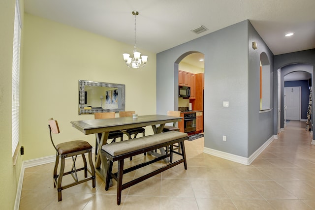 dining space with a chandelier and light tile patterned flooring