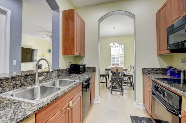 kitchen with ceiling fan with notable chandelier, black appliances, sink, hanging light fixtures, and light tile patterned flooring