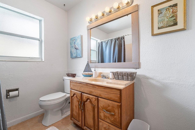 bathroom with baseboards, toilet, a textured wall, tile patterned floors, and vanity