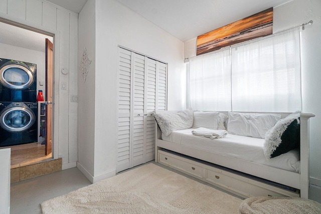 bedroom with a closet and stacked washer and clothes dryer