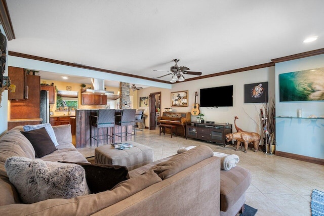 living room featuring crown molding, light tile patterned floors, a ceiling fan, and baseboards