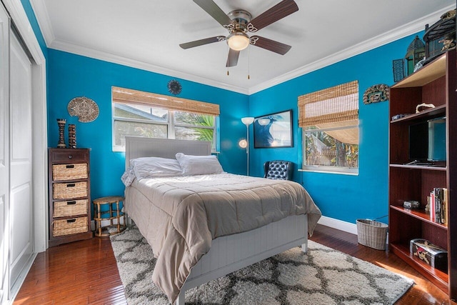 bedroom with ceiling fan, a closet, crown molding, and dark hardwood / wood-style flooring