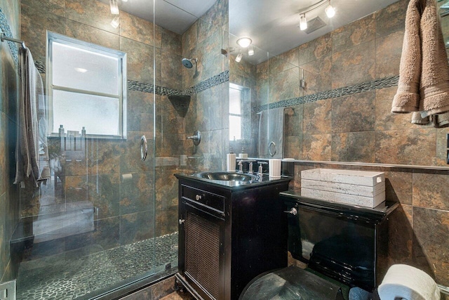 bathroom featuring tile walls, walk in shower, and vanity