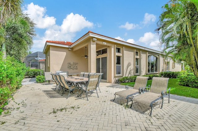 view of patio / terrace featuring glass enclosure and ceiling fan