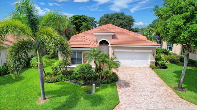 mediterranean / spanish home with a front lawn and a garage