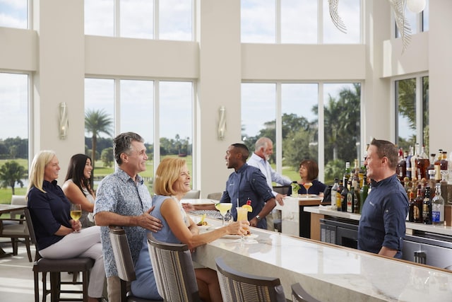 dining room with a towering ceiling and bar