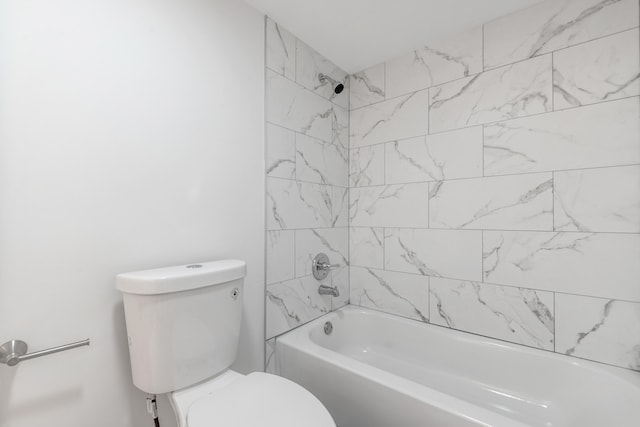 bathroom featuring tiled shower / bath combo and toilet