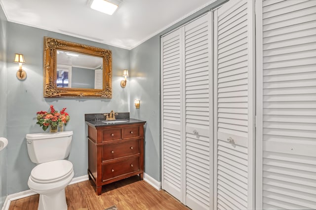 bathroom featuring ornamental molding, hardwood / wood-style floors, vanity, and toilet