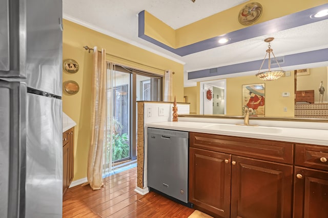 kitchen with ornamental molding, stainless steel appliances, dark hardwood / wood-style flooring, pendant lighting, and sink