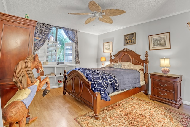 bedroom featuring ornamental molding, light hardwood / wood-style floors, a textured ceiling, and ceiling fan