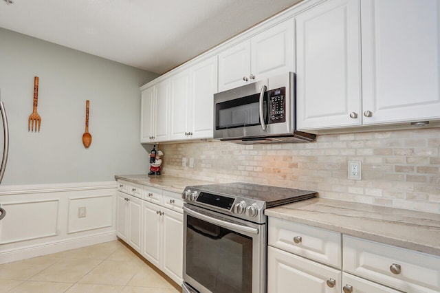 kitchen featuring white cabinets, appliances with stainless steel finishes, and light stone countertops