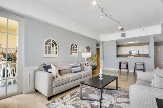 living room featuring track lighting and light tile patterned floors