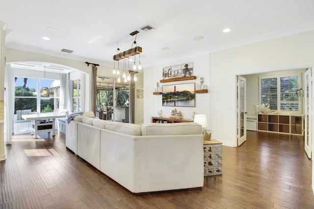 living room with ornamental molding, dark hardwood / wood-style floors, and a chandelier