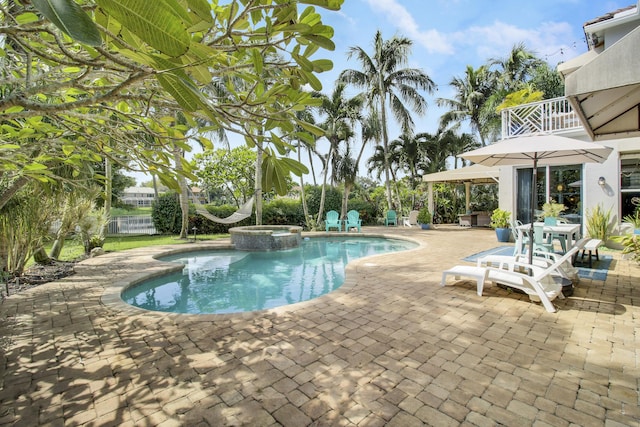 view of swimming pool featuring a patio area and an in ground hot tub