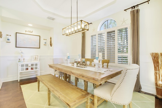 dining space with hardwood / wood-style flooring and a tray ceiling