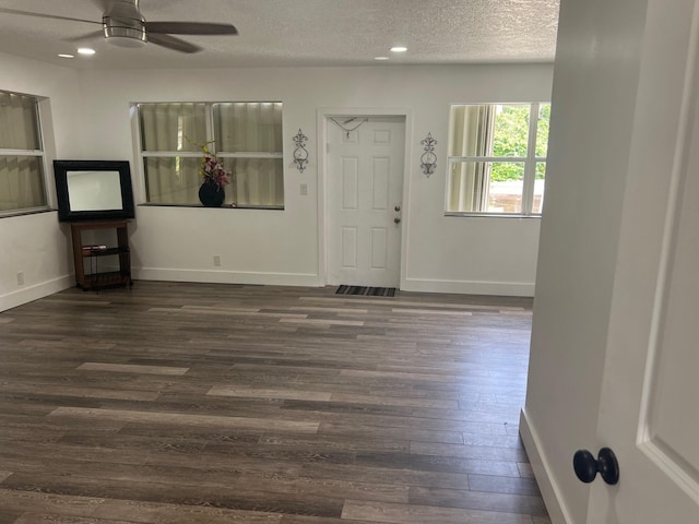 foyer entrance featuring dark wood-type flooring, ceiling fan, and a textured ceiling