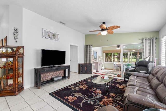 tiled living room with ceiling fan, a textured ceiling, and vaulted ceiling