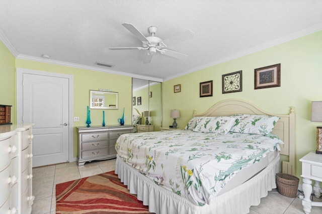 tiled bedroom with ornamental molding, ceiling fan, and a textured ceiling