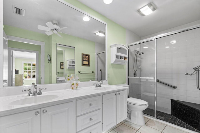 bathroom featuring vanity, toilet, ceiling fan, and a shower with shower door