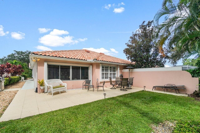 rear view of house featuring a patio and a yard