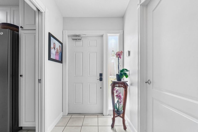 foyer entrance featuring a textured ceiling and light tile patterned floors