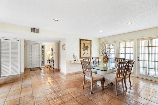 dining room with light tile patterned floors and a textured ceiling