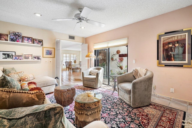 living room featuring a textured ceiling and ceiling fan