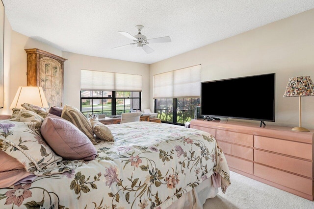 bedroom featuring a textured ceiling, carpet floors, and ceiling fan