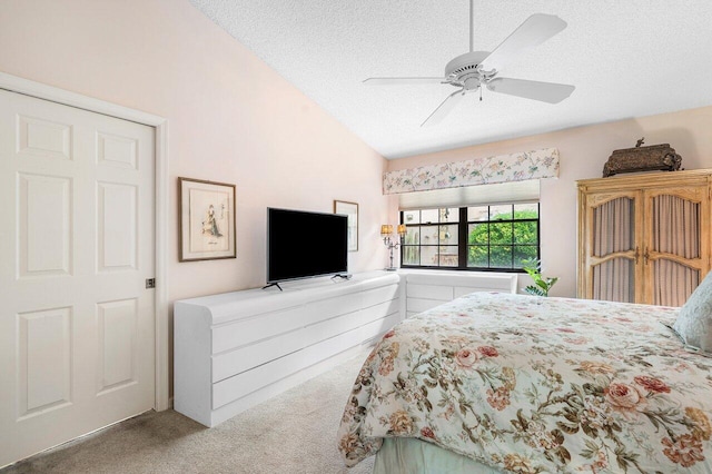 carpeted bedroom featuring a textured ceiling, vaulted ceiling, and ceiling fan