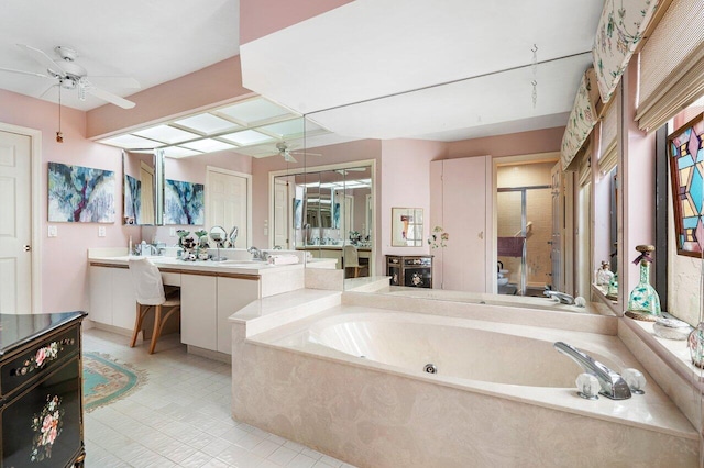 bathroom featuring tile patterned flooring, a relaxing tiled tub, ceiling fan, and vanity