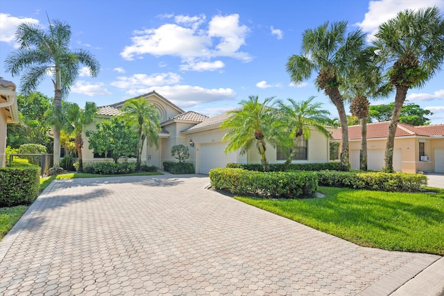 mediterranean / spanish-style house featuring a front yard and a garage