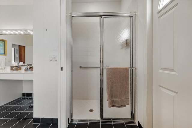 bathroom featuring tile patterned flooring, a shower with door, and vanity