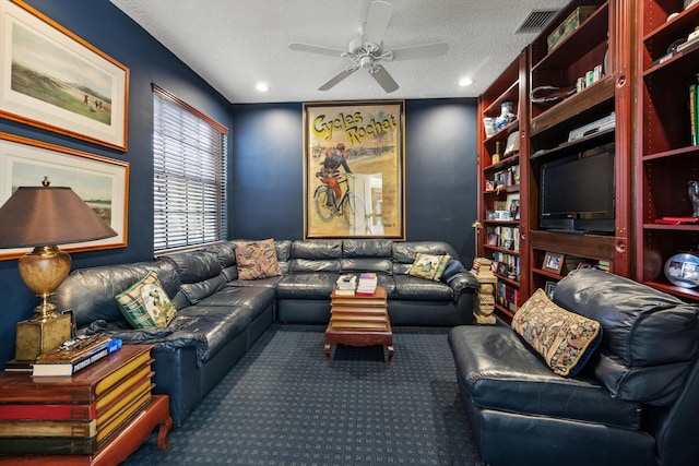 carpeted living room featuring ceiling fan and a textured ceiling