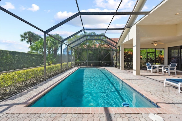 view of pool with ceiling fan, a lanai, and a patio area