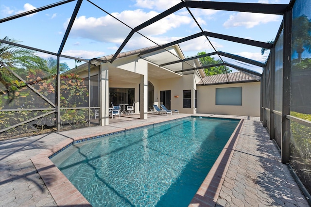 view of swimming pool with glass enclosure and a patio area