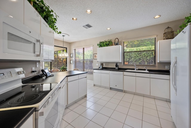 kitchen featuring plenty of natural light, white appliances, and white cabinetry