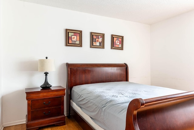 bedroom featuring light hardwood / wood-style floors and a textured ceiling