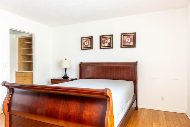 unfurnished bedroom featuring a textured ceiling and light hardwood / wood-style flooring